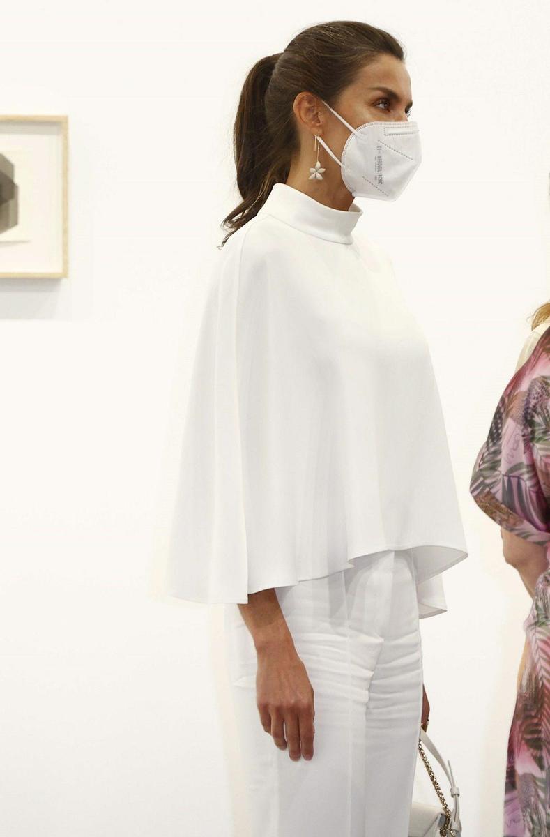 La reina Letizia, con capa y pantalón en color blanco, durante su visita a ARCO Madrid