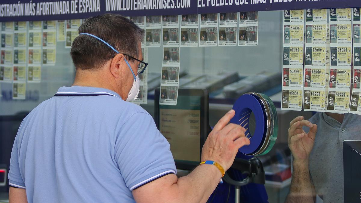 Un hombre compra lotería en una Administración en Manises