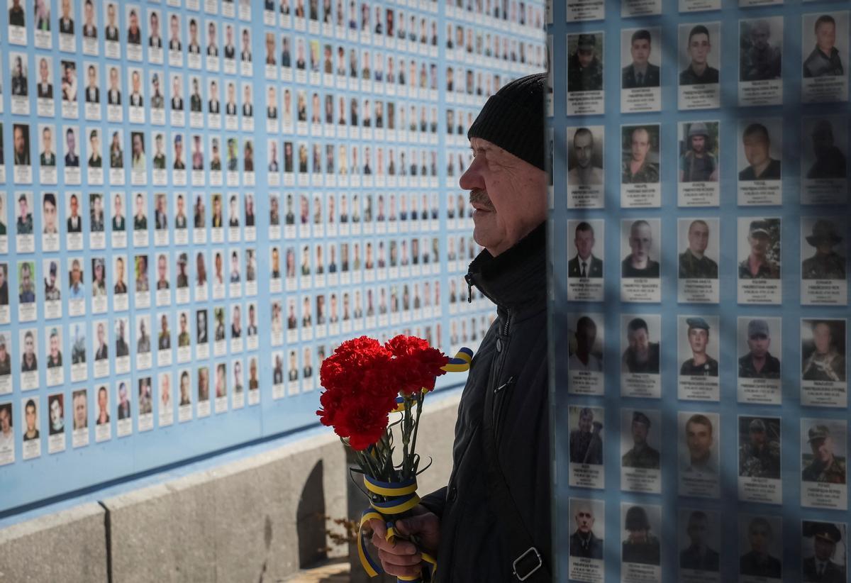 La gente visita el Muro del Recuerdo para conmemorar el Día de los Voluntarios en honor a los combatientes muertos que se unieron a las fuerzas armadas ucranianas.