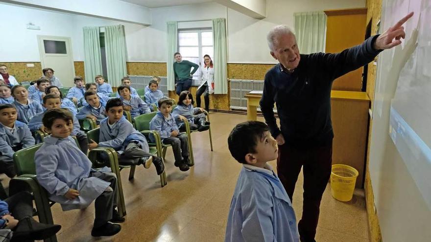 Melchor Fernández Díaz muestra una fotografía de El Entrego a un escolar.