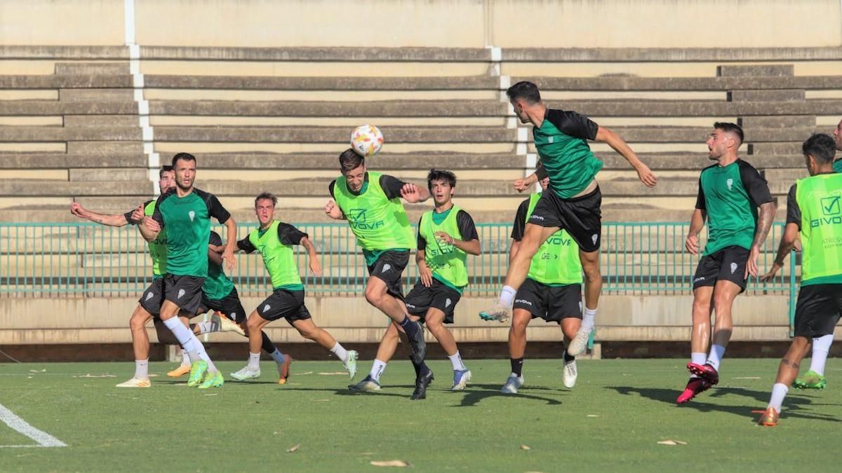 La zaga del Córdoba CF B despeja un balón aéreo en su área.