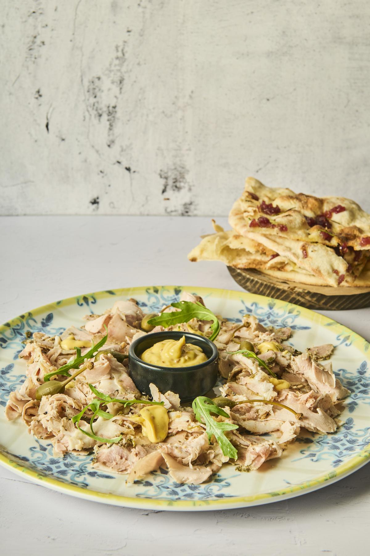Antipasto de Porchetta Asada de La Mafia se sienta a la mesa.