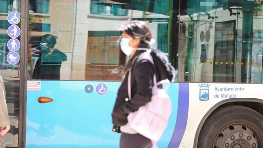 Una mujer esperando en una parada de la EMT