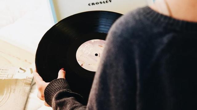 Una persona subjecta un vinil de color negre.