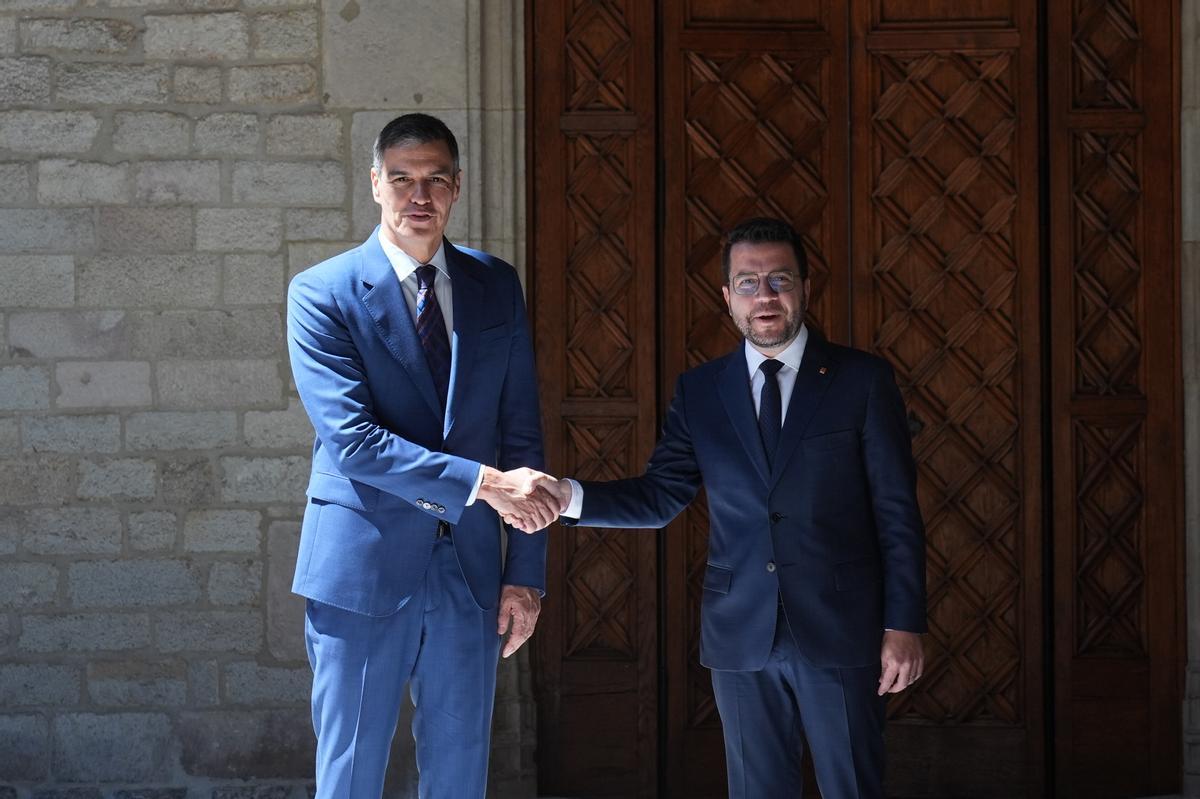 El presidente del Gobierno, Pedro Sánchez (i), y el presidente de la Generalitat en funciones, Pere Aragonès (d), se saludan a su llegada a su reunión en el Palau de la Generalitat.
