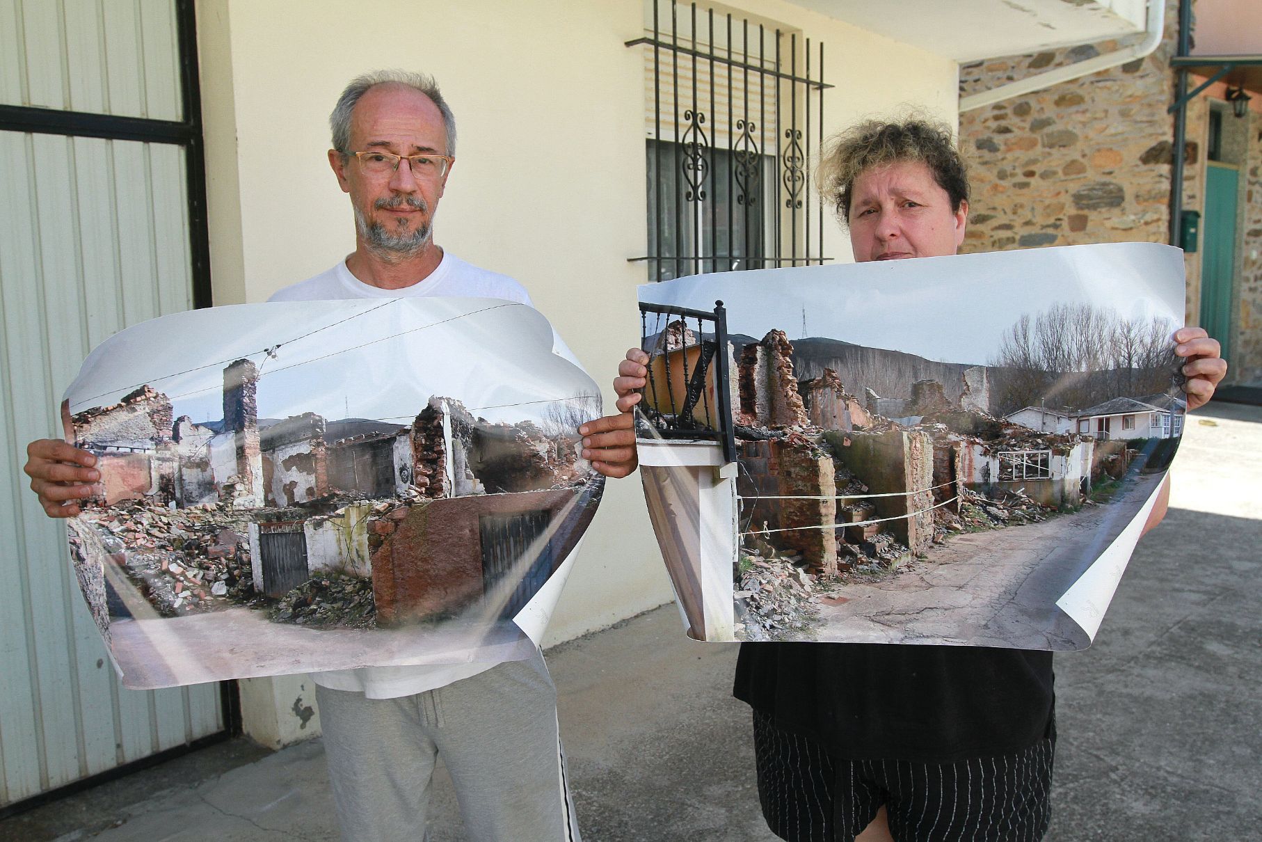 Pedro y Beatriz, vecinos de A Veiga de Cascallá con fotos de viviendas que quedaron arrasadas