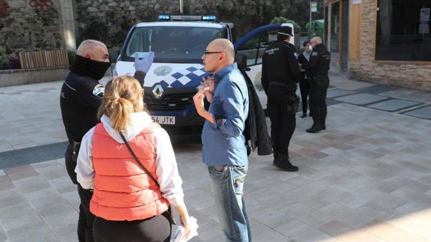 Agentes de la Policía Local controlando a vecinos de Vigo en la calle tras decretarse el estado de alarma. // Ricardo Grobas