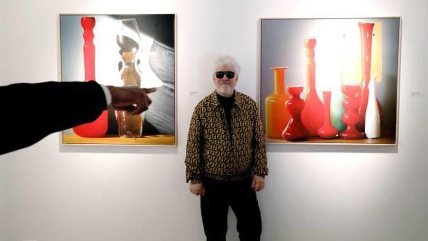 Pedro Almodóvar posa ante dos de sus obras expuestas en Manhattan.