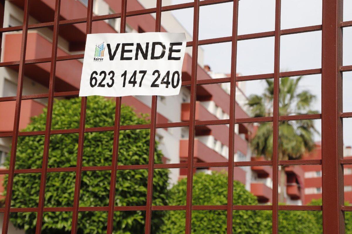 Cartel de "se vende" en la cancela de entrada de unos pisos en Córdoba capital