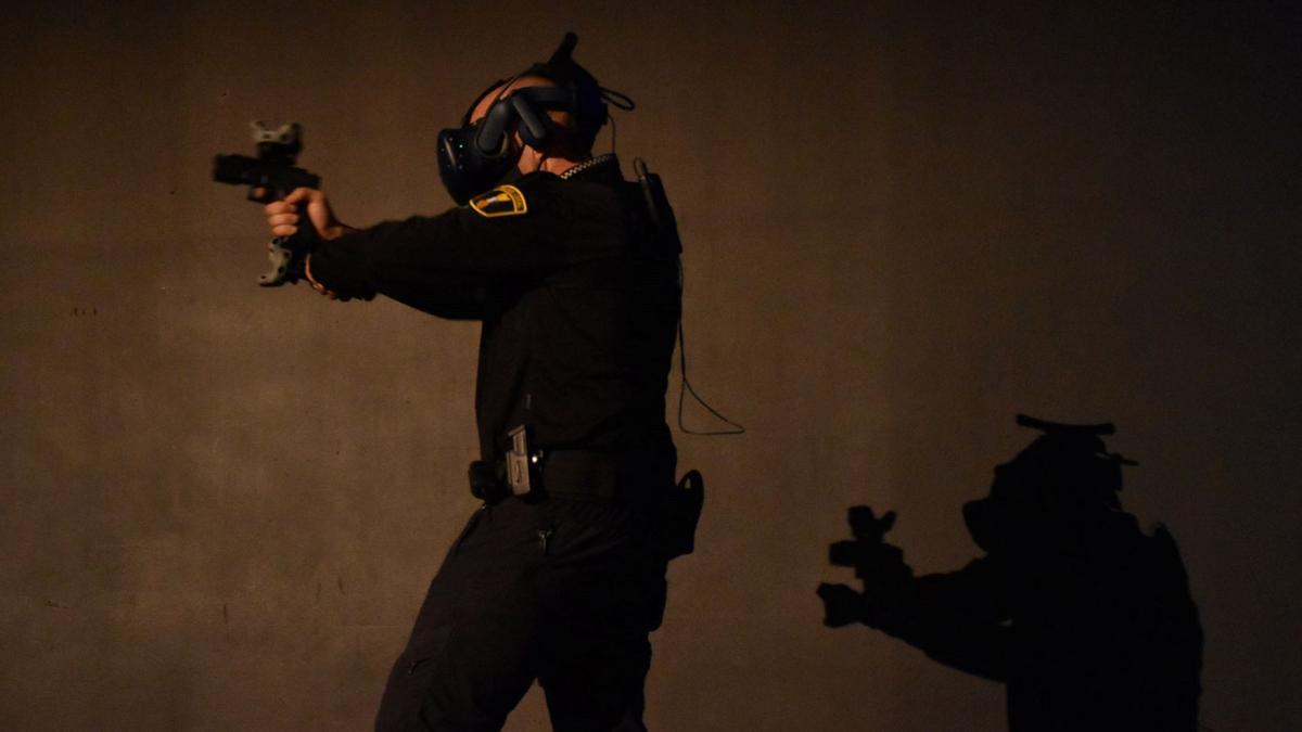 Un agente, con el arma simulada y un casco de realidad virtual