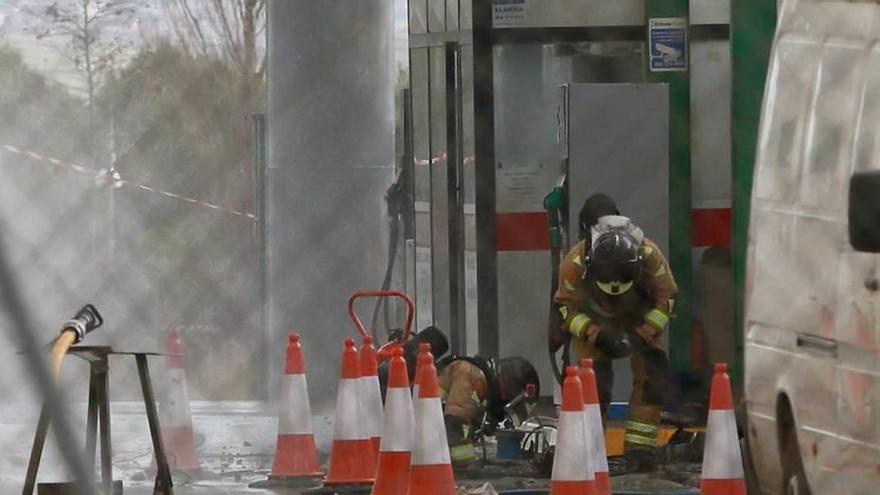 Un bombero inspecciona el depósito de la explosión.