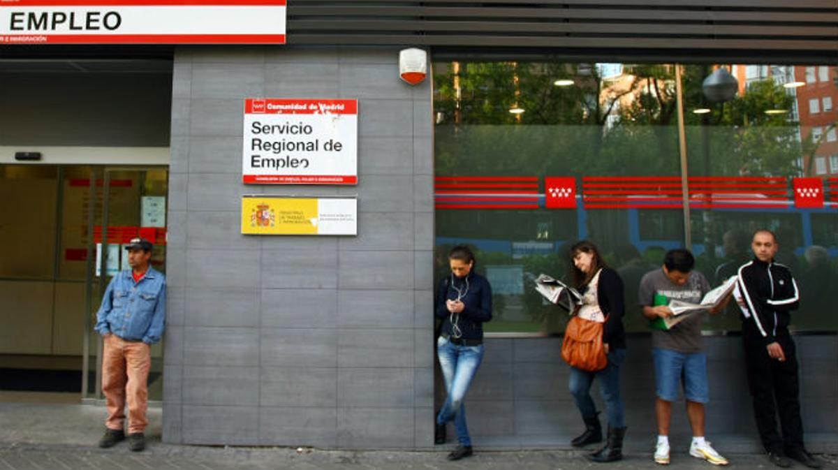 Diversos ciutadans esperen que obri una oficina d’ocupació de Madrid, l’abril passat.