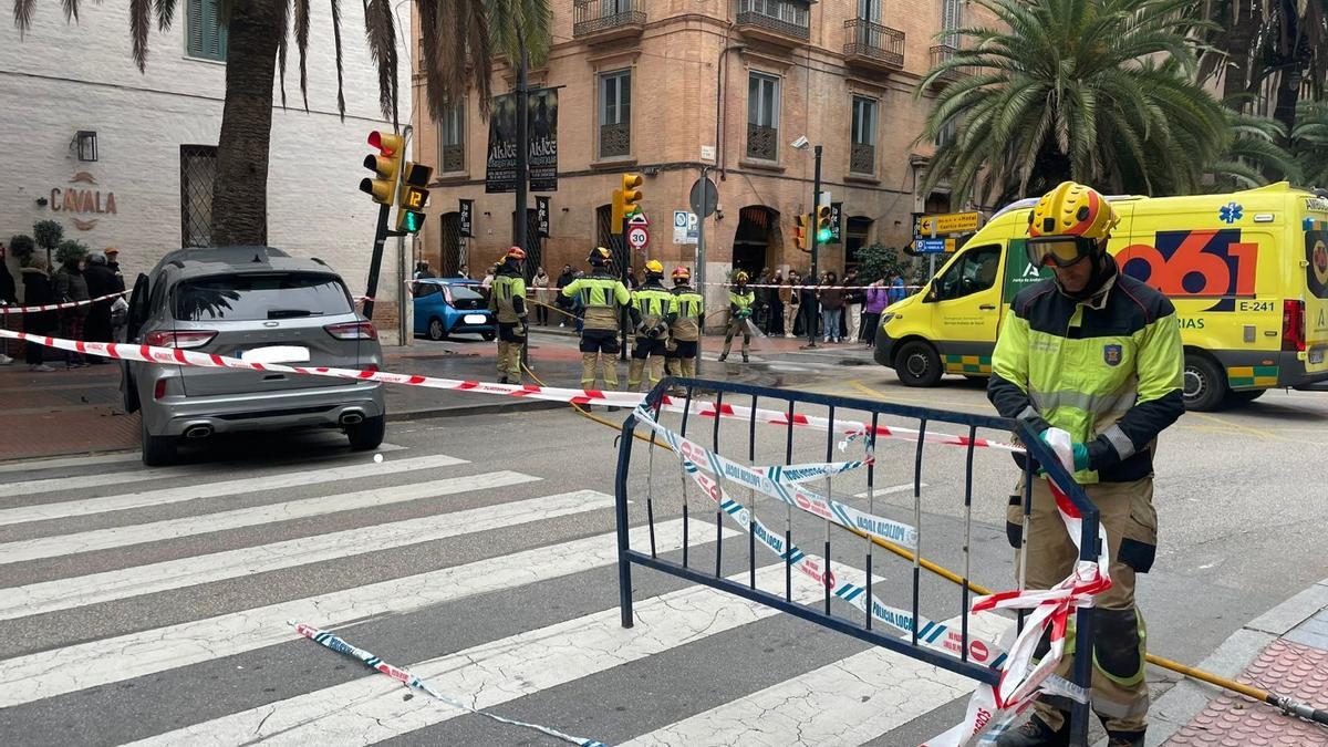 Varios bomberos trabajan junto a uno de los vehículos implicados.