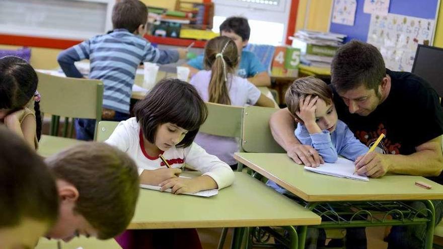 Un profesor en el colegio de Vilariño de Conso ayuda a uno de sus alumnos.