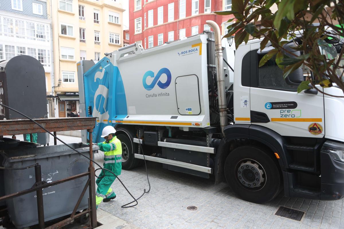 Trabajadores de la concesionaria de recogida de residuos vaciando contenedores.