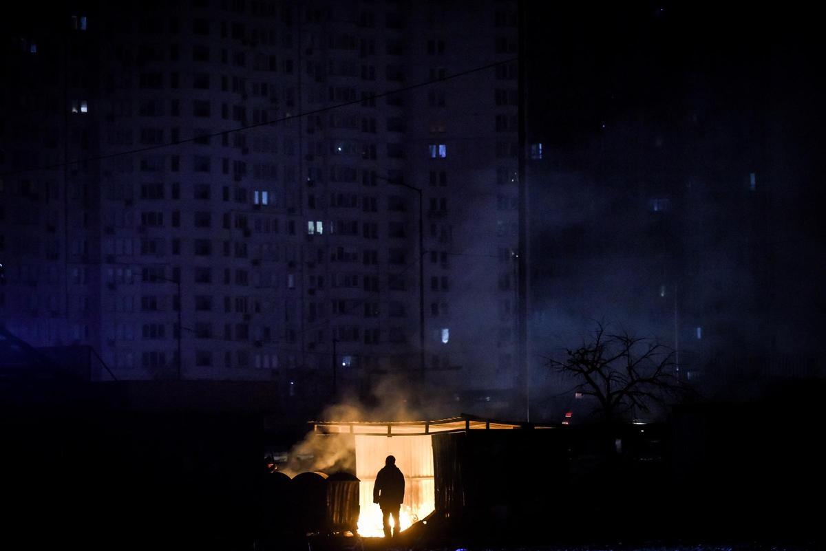 KIEV (UCRANIA), 29/11/2022.- Un hombre frente a una hoguera en la que se quema basura frente a un edificio de apartamentos durante un corte de energía programado