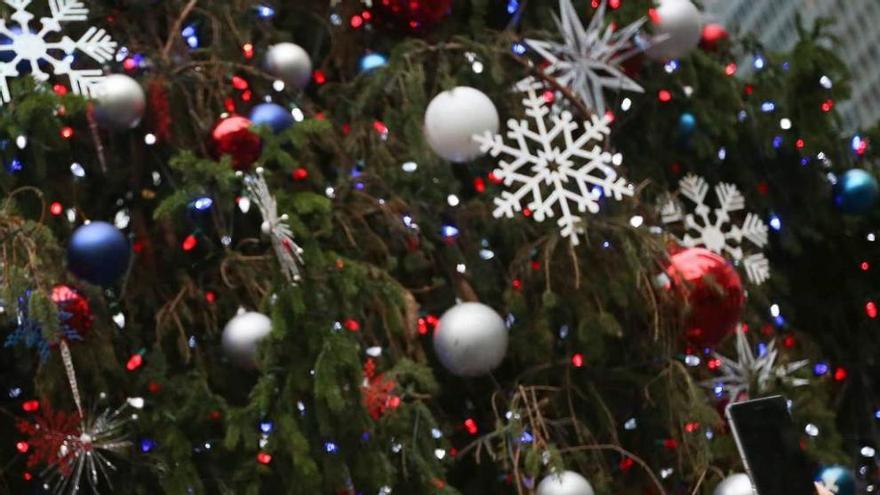 A la izquierda, una pareja haciéndose un &quot;selfie&quot; con un árbol de Navidad detrás. A la derecha, un viandante en pantalón corto por las calles de Nueva York.