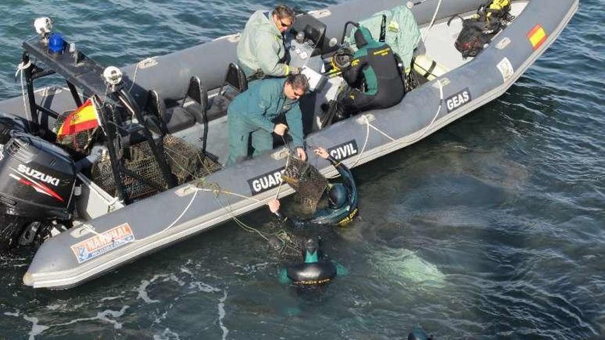 Los buzos de la Guardia Civil, buscando el material de pesca.