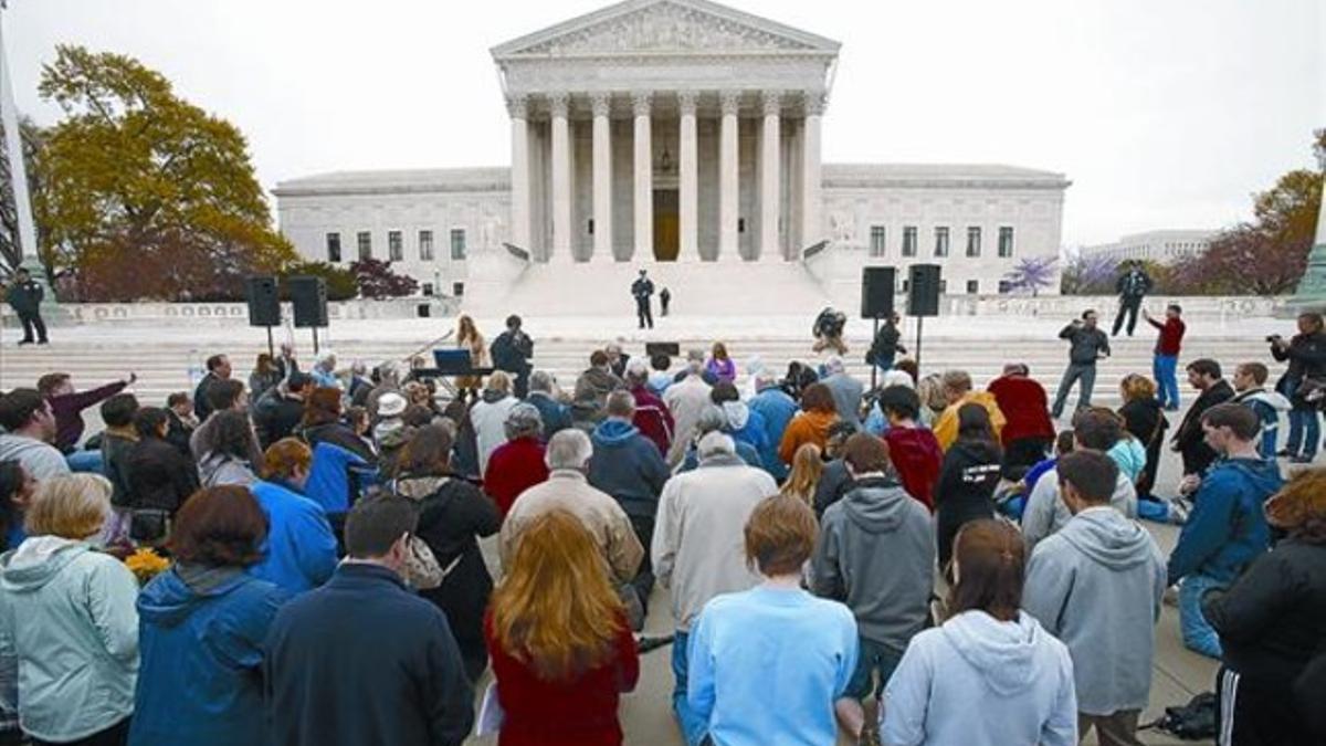 Un grupo de cristianos se pone de rodillas a rezar frente al Tribunal Supremo de EEUU, en Washington, ayer.
