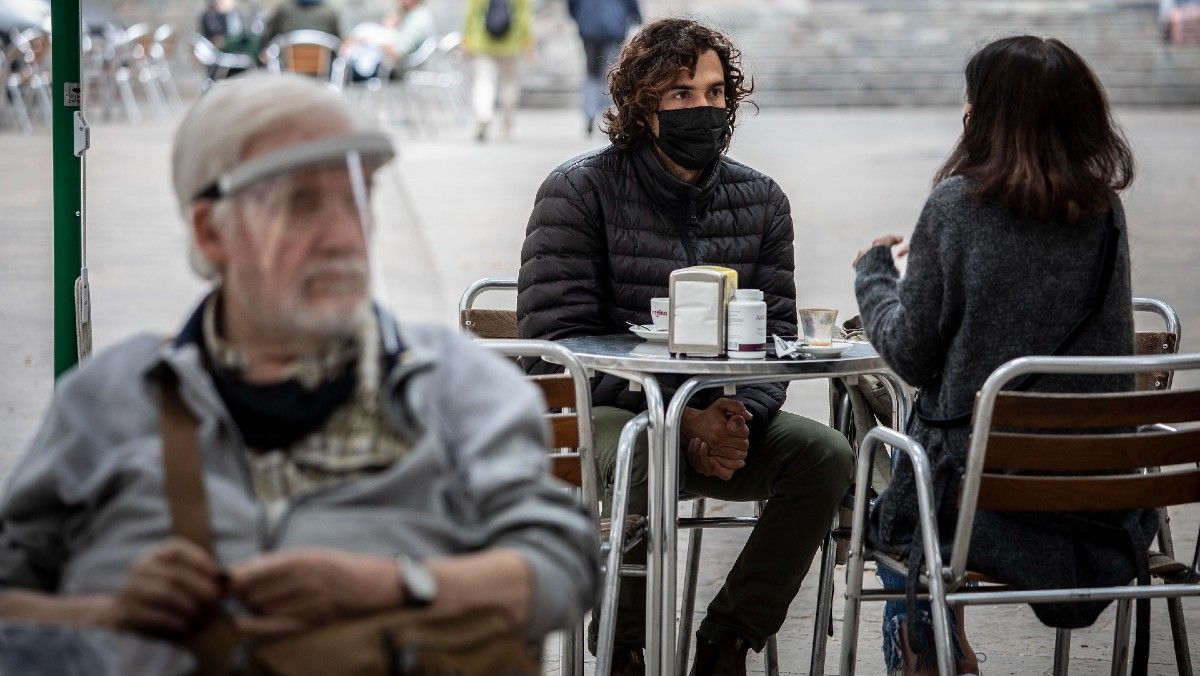 Un hombre lleva mascarilla en la terraza de un bar, en Barcelona.