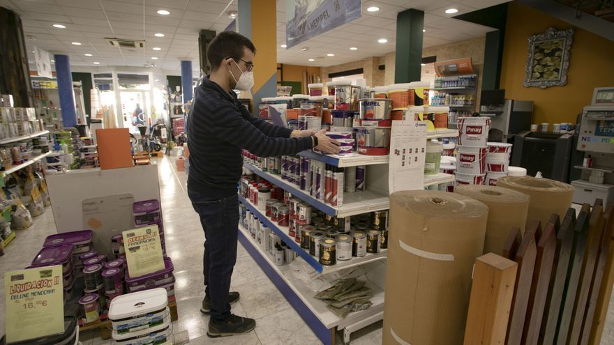 Un profesional del comercio sitúa productos en los estantes de su tienda.