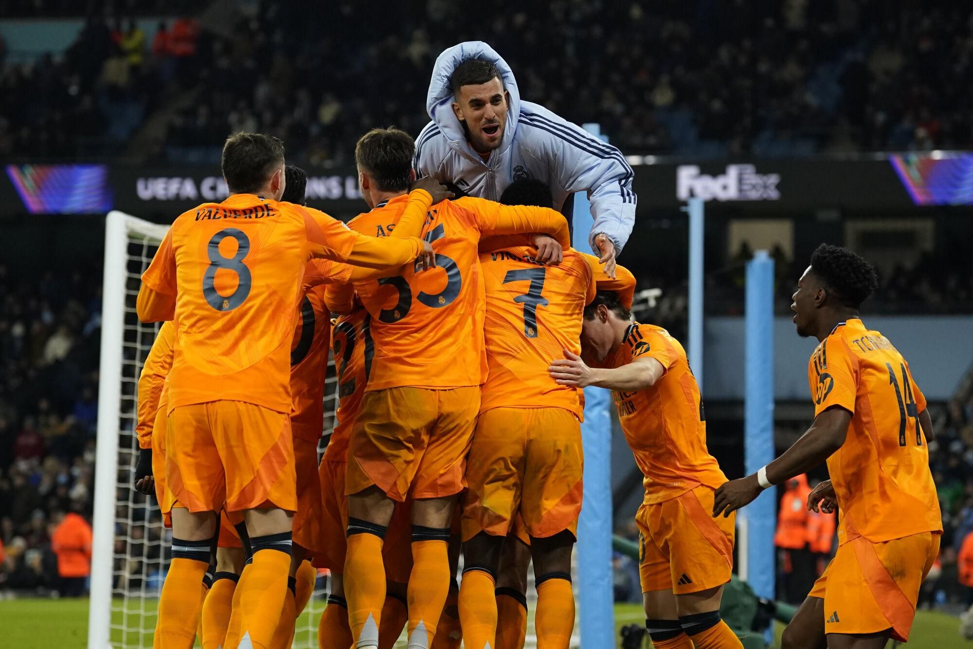 Real Madrid's Jude Bellingham celebrates with teammates after scoring his sides third goal during the Champions League playoff first leg soccer match between Manchester City and Real Madrid at the Etihad Stadium in Manchester, England, Tuesday, Feb. 11, 2025. (AP Photo/Dave Thompson)