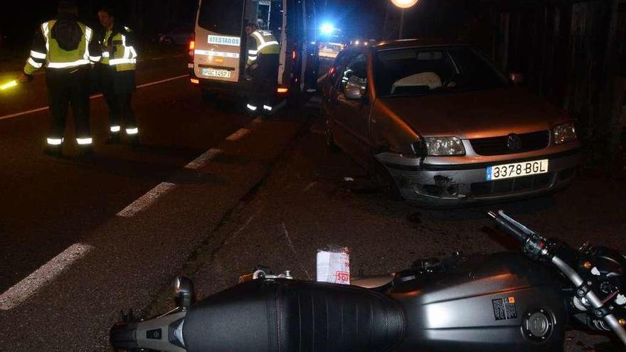 La motocicleta tumbada en el suelo y el turismo Polo, en el lugar del accidente en Domaio. // Gonzalo Núñez