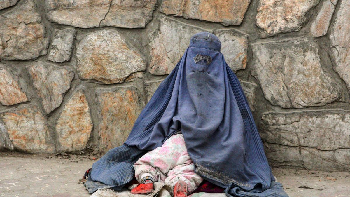 Una mujer afgana mendigando con su hija pequeña escondida bajo el burka en el barrio de Share Naw, en el centro de Kabul.