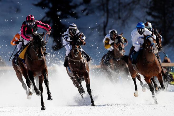 Participantes en el tercer domingo de carreras de caballos sobre la nieve del White Turf St. Moritz celebrado en el lago helado de la localidad suiza de St.Moritz.