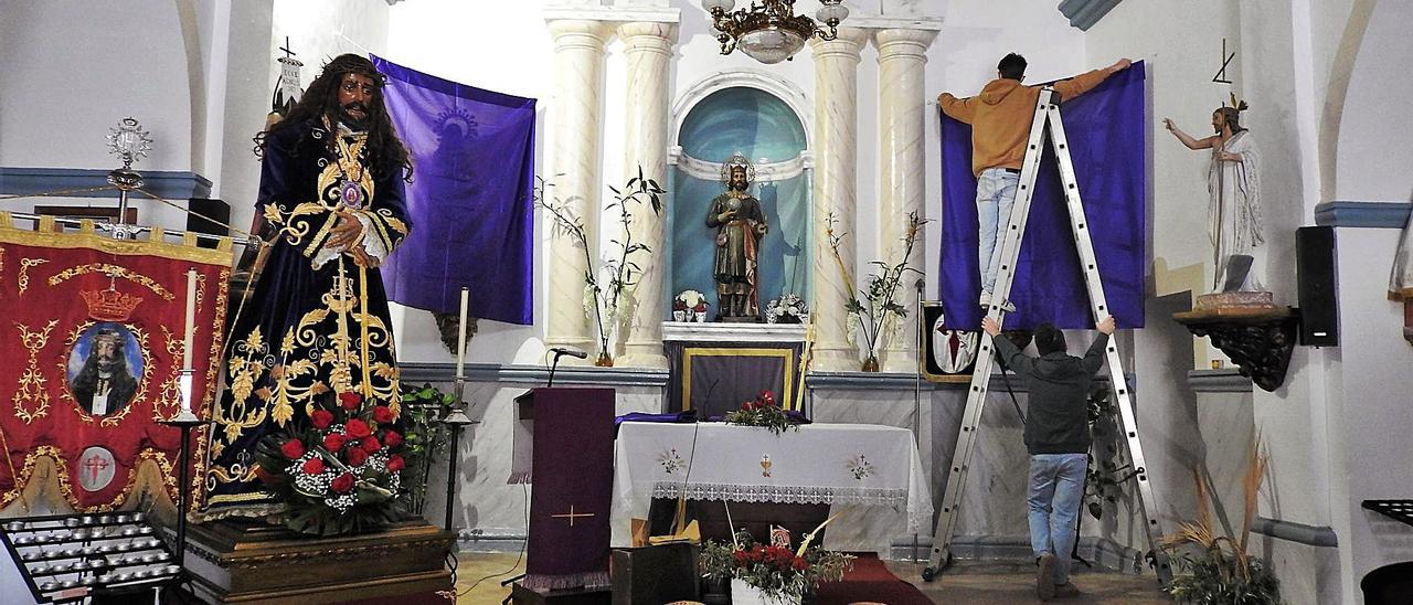 Dos jóvenes de la Fundación Hakuna decoran el interior de la iglesia de Sant Ferran de ses Roques.