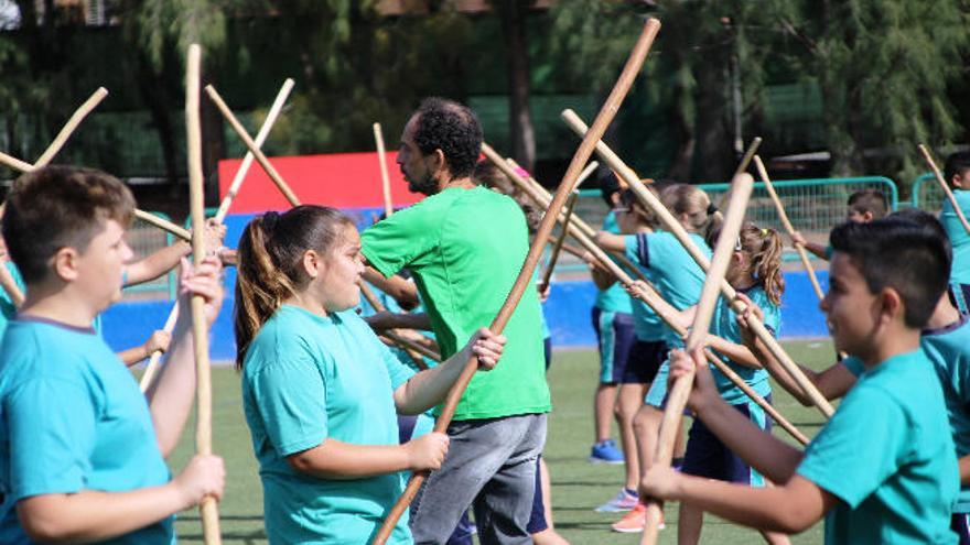 Los estudiantes practican la lucha del garrote.