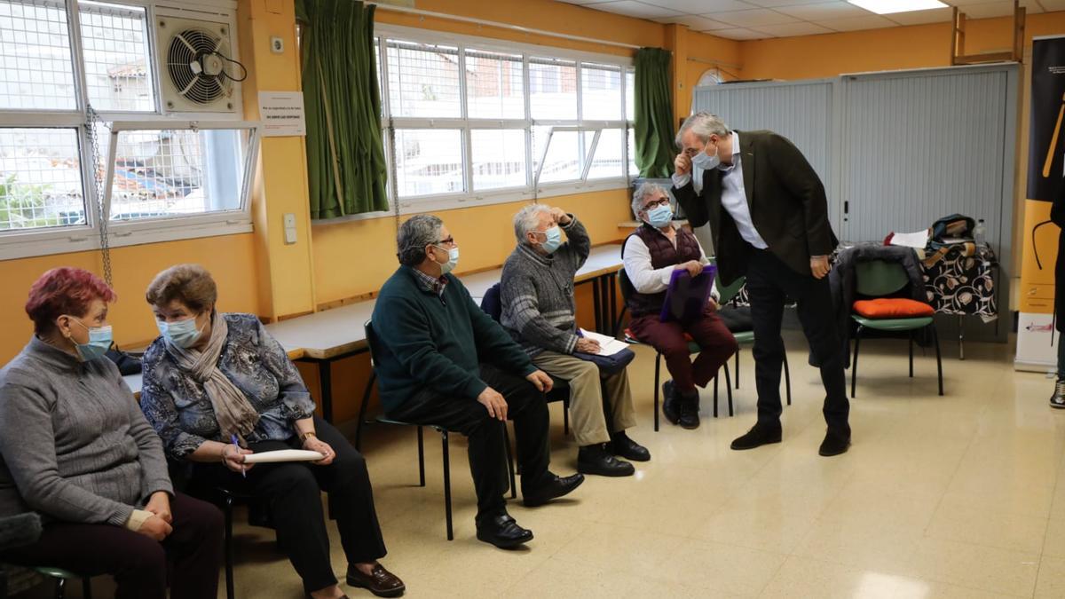 Azcón, de pie, saludando a los participantes del programa &#039;Nos gusta hablar&#039; en el centro de mayores del Oliver.