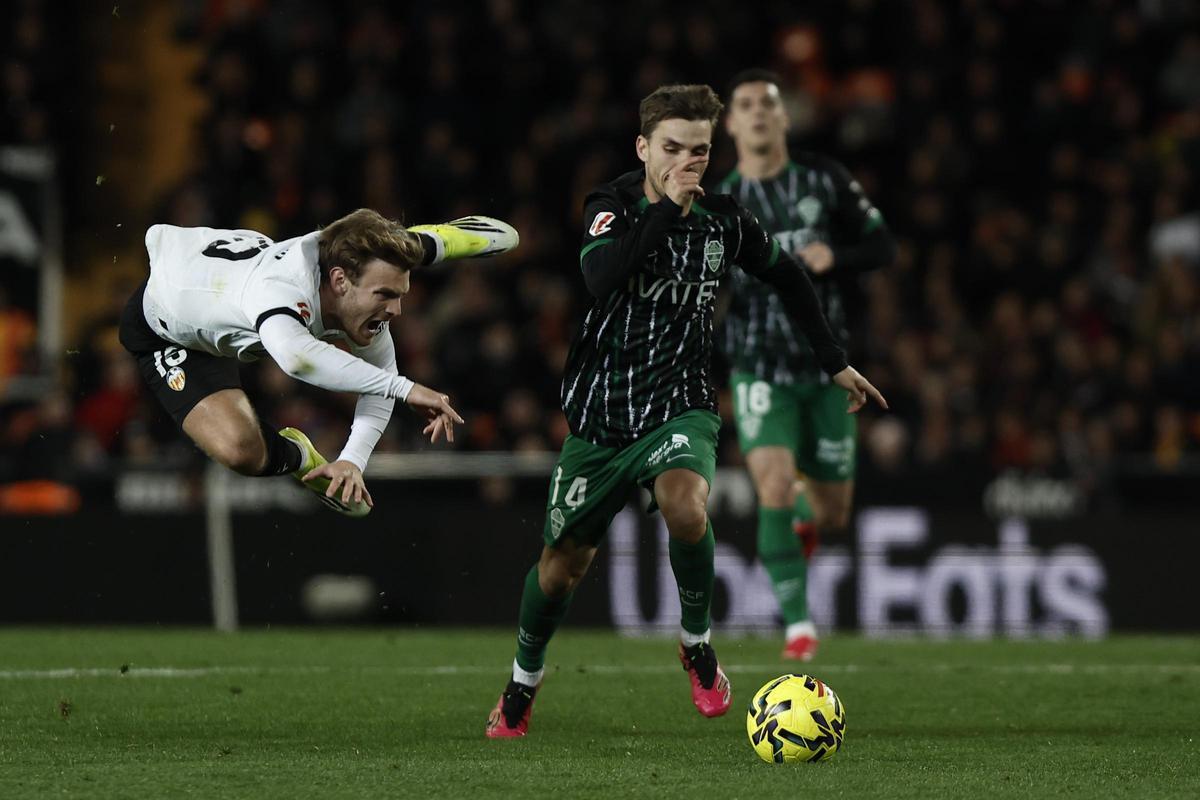 Febas conduce el balón durante el Valencia-Elche, ante el salto de un rival
