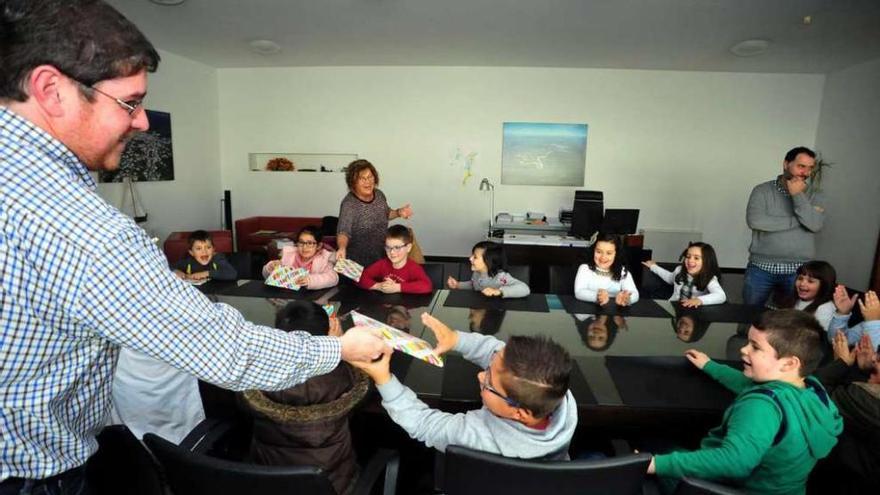 Carlos Iglesias entrega varios libros de Os Bolechas a los pequeños del colegio A Torre. // Faro