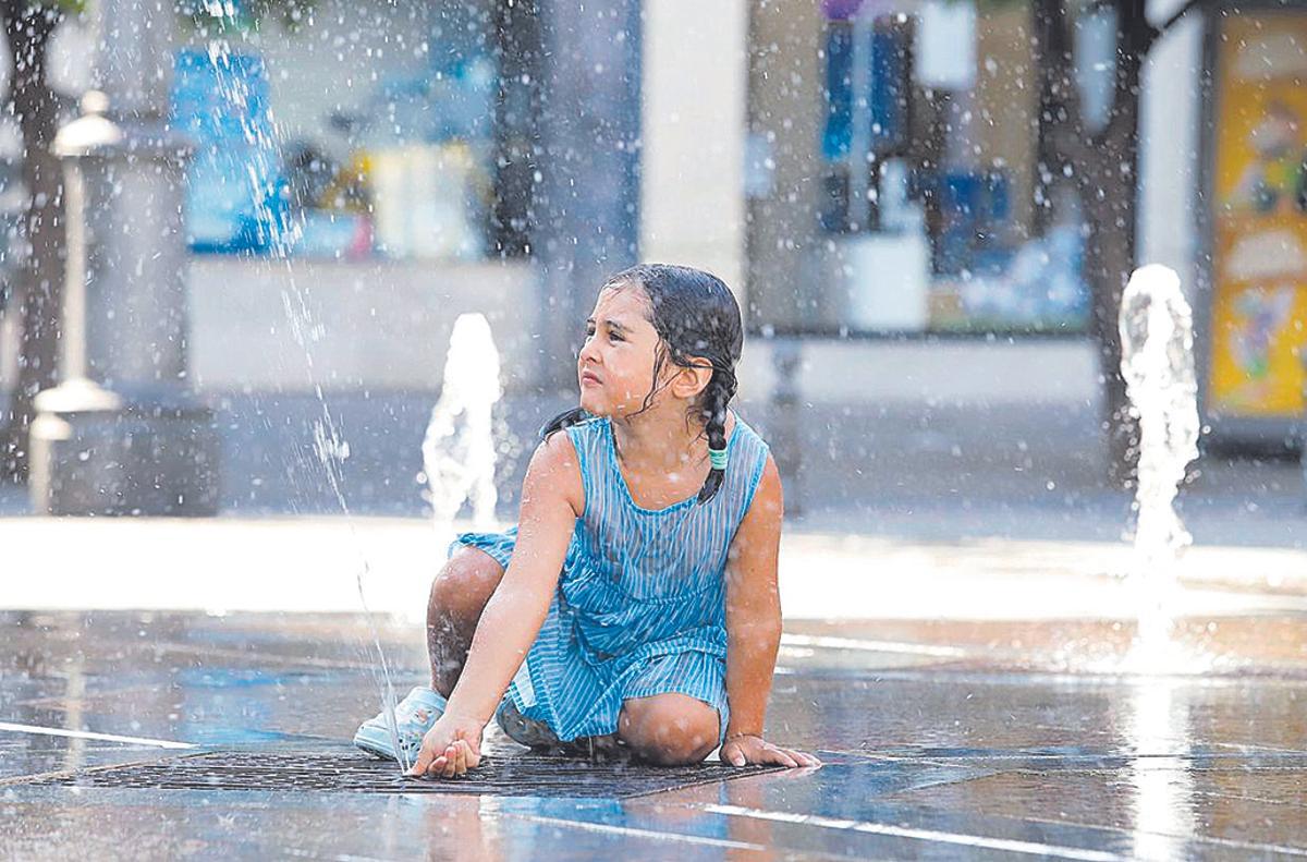 Una pequerña juega en los ‘chorros’ de la plaza de Las Tendillas durante este verano