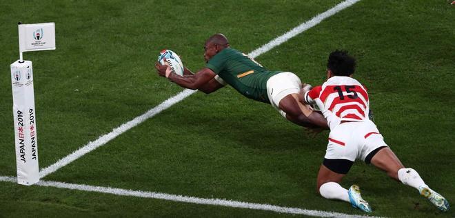 El ala sudafricana Makazole Mapimpi (L) anota un try durante el partido de cuartos de final de la Copa Mundial de Rugby de Japón 2019 entre Japón y Sudáfrica en el Estadio de Tokio en Tokio.