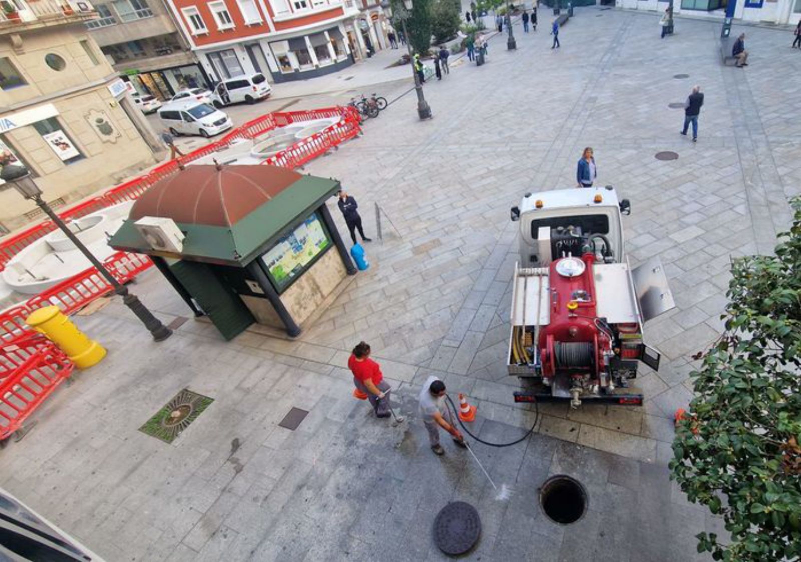 Operarios tratando de desatascar la tubería que va desde la plaza de Galicia a la alcantarilla en cuestión.
