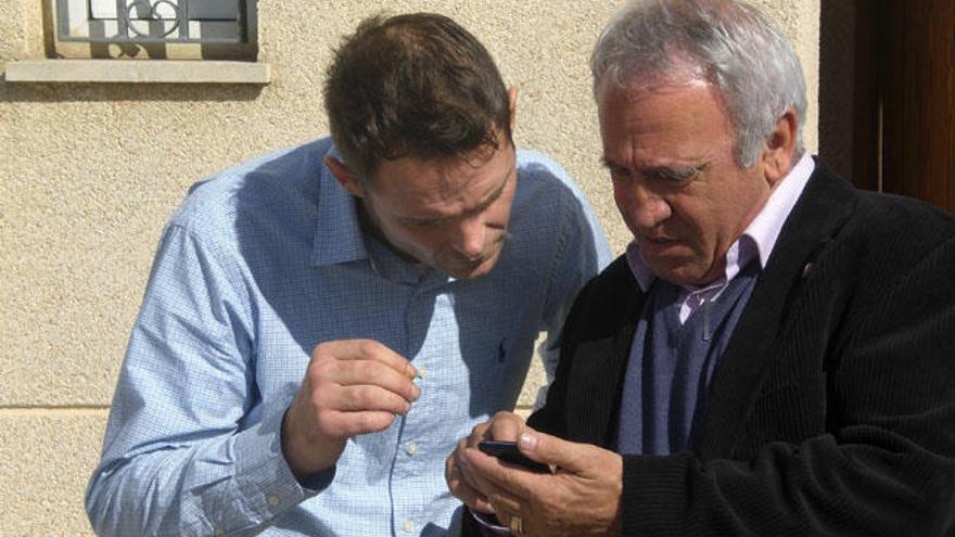 Romano y el padre Jaume Alemany con su nuevo teléfono móvil.