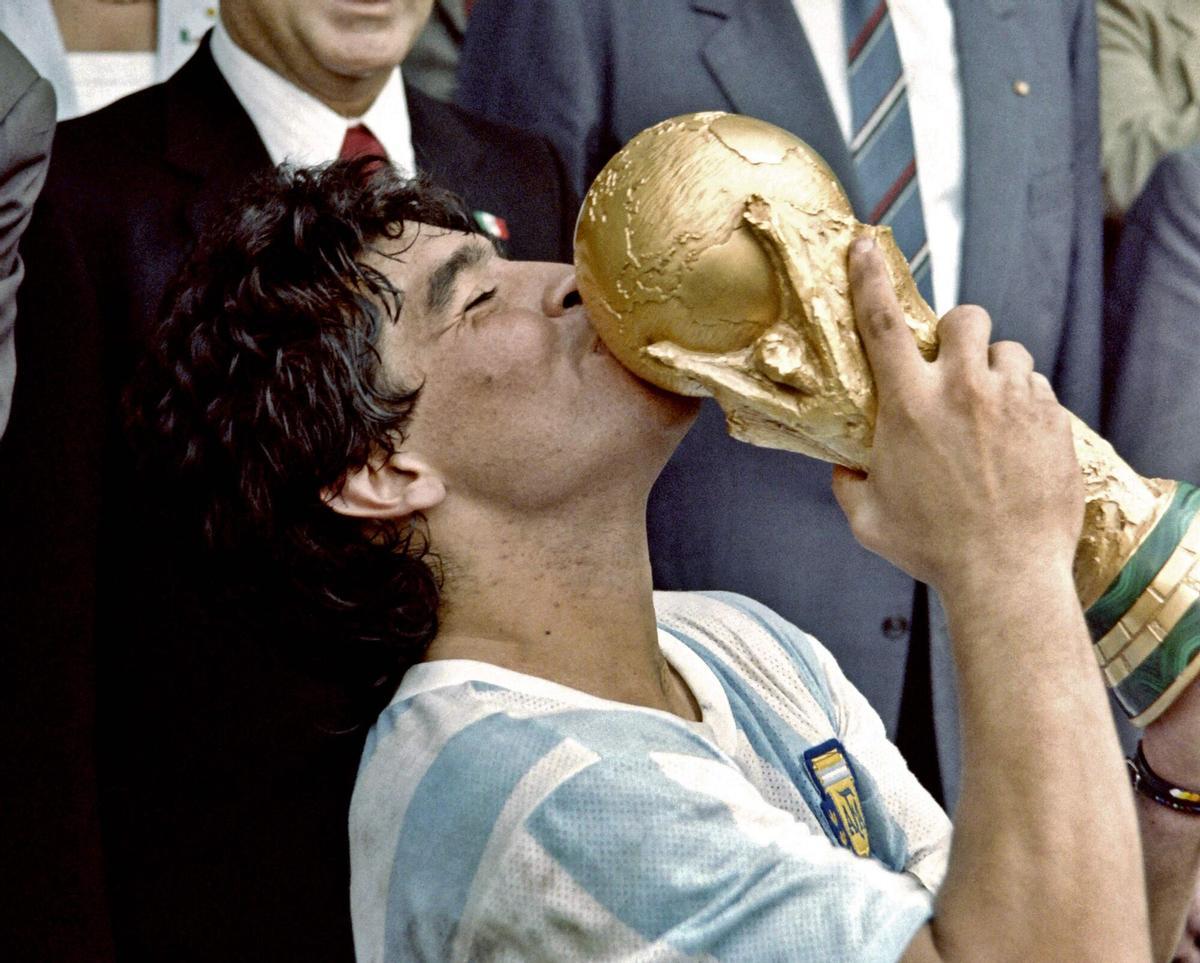(FILES) In this photo taken on June 29, 1986 Argentina's football star team captain Diego Maradona kisses the World Soccer Cup won by his team after a 3-2 victory over West Germany on at the Azteca stadium in Mexico City. Diego Armando Maradona. That name sums up the 1986 World Cup. "El Pelusa", a hero at Napoli, managed to lead a much-criticised Argentina – a team that had struggled immensely to qualify – to ultimate victory. (Photo by Dominique FAGET / AFP). TO GO WITH AFP STORY ON HISTORY OF THE FOOTBALL WORLD CUP