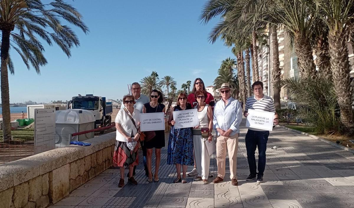 Un grupo de vecinos, el pasado miércoles en el paseo marítimo Ciudad de Melilla, junto a las obras de ampliación de uno de los merenderos. | A.V.