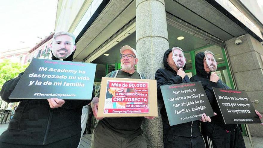 Juantxo Domínguez, presidente de la asociación RedUNE, con afectados por  la criptosecta IM Mastery Academy, en una protesta  en Madrid en mayo. |   
// ALBERTO ORTEGA / EUROPA PRESS