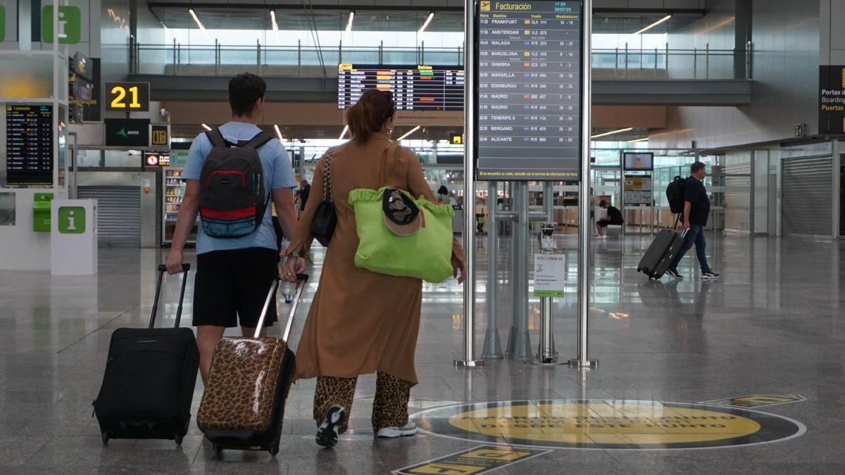 os viajeros con sus maletas en el aeropuerto de Santiago