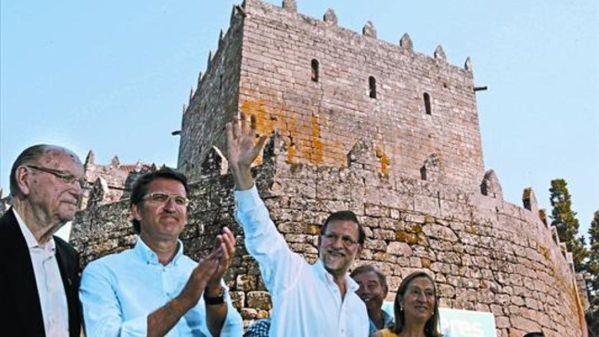 Rajoy, entre el presidente gallego, Alberto Núñez Feijóo, y la ministra Ana Pastor, saluda al término del acto celebrado ayer en Soutomaior.
