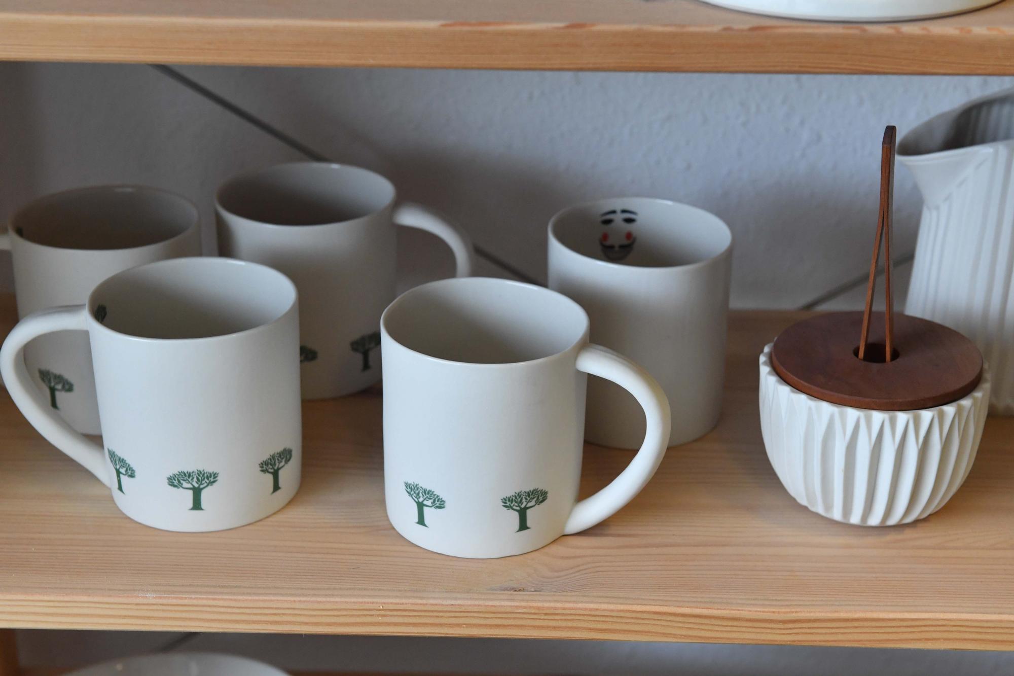 Laura Delgado con los vasos tiki ganadores, una combinación de culturas entre Polinesia y Galicia, y otras obras realizadas por esta ceramista en su taller de Cambre, en el que también da clases a pequeños grupos.