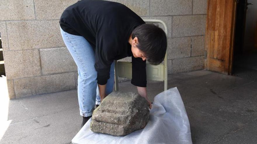 Una técnica del museo arqueológico, ayer, con el pedestal del ‘cruceiro’ hallado en la ría.   | // VÍCTOR ECHAVE