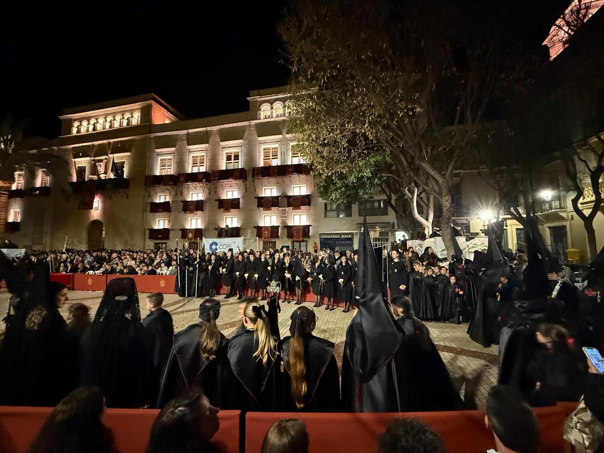 Concentración de nazarenos y mantillas en la Plaça de Baix tras el paso del Santo Entierro