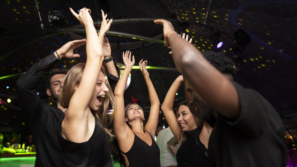 Varios jóvenes se divierten en una fiesta dentro de una discoteca