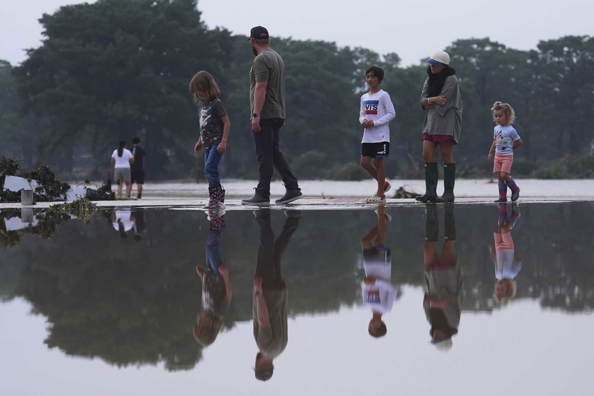 Onlookers survey damage along the Guadalupe River after a flash flood swept through the area, Friday, July 4, 2025, in Kerrville, Texas. (AP Photo/Eric Gay)
