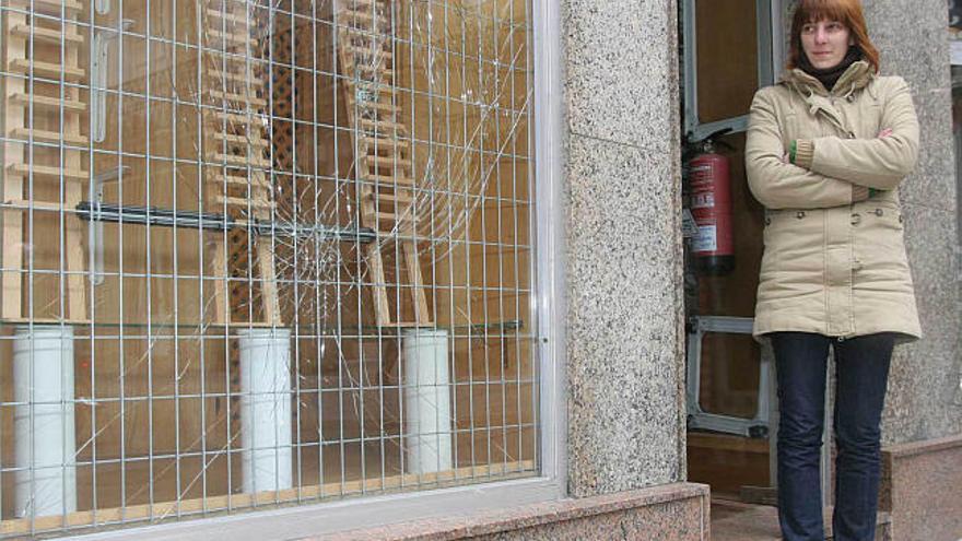 Yolanda Ríos, dueña de una ferretería en la calle Plaza, observa los destrozos en el escaparate.