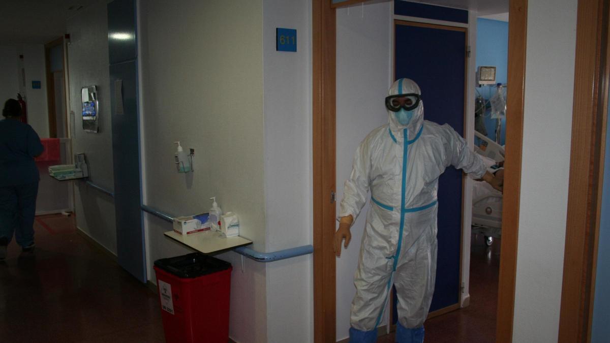 Un enfermero con EPI abandona la habitación de un enfermo de coronavirus en el Rafael Méndez.
